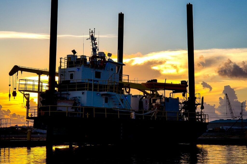 Liftboat is positioned on the three pipe legs over the water's surface. this liftboat is equipped with a crane and is used for construction purposes.