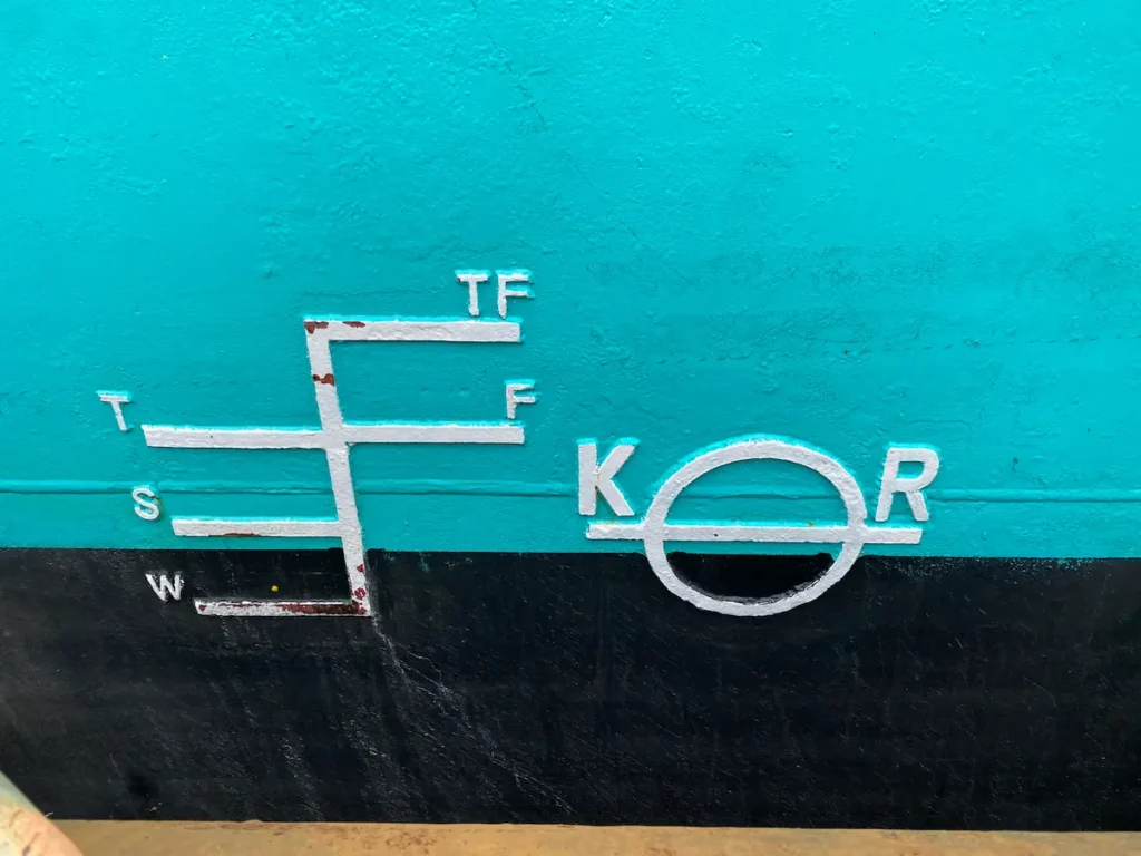 Image of an International Load Line Marking on a ship, featuring a Plimsoll Disk and the initials 'KR' denoting the class society.