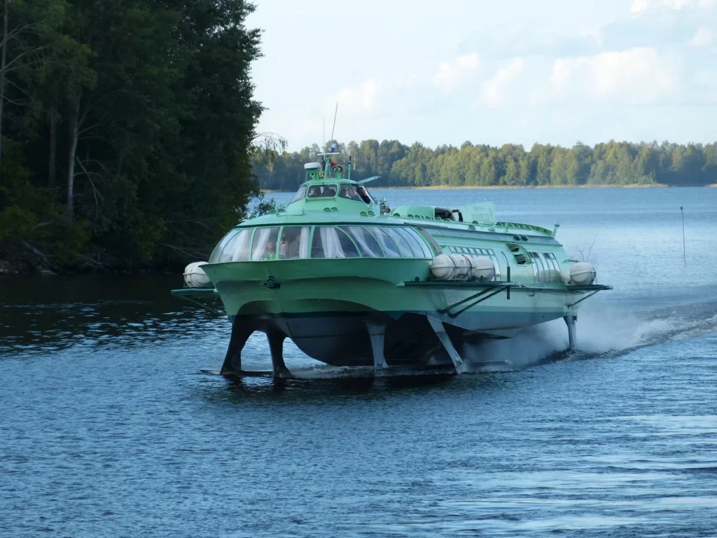 Passenger hydrofoil boat at high speed cruising in the river close to the shore