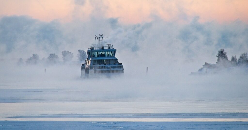 A shipping vessel surrounded by sea smoke