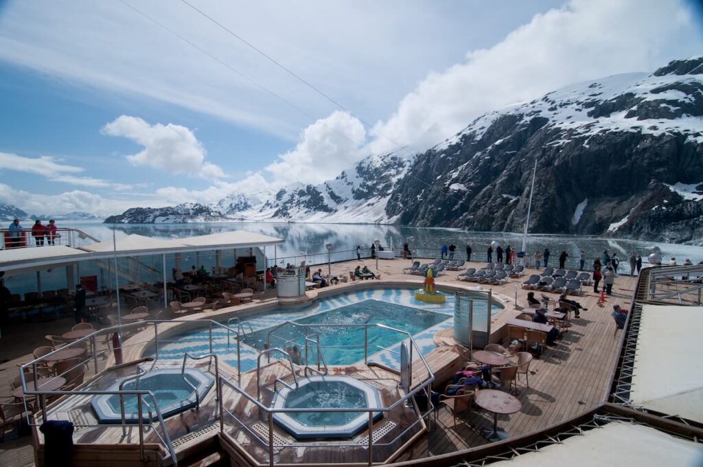 Passengers on the upper deck watching on the high cliffs of Alaskan fjords on their winter cruise