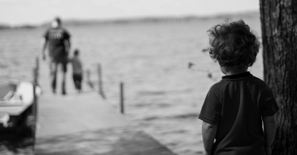 a young boy looking at a boat